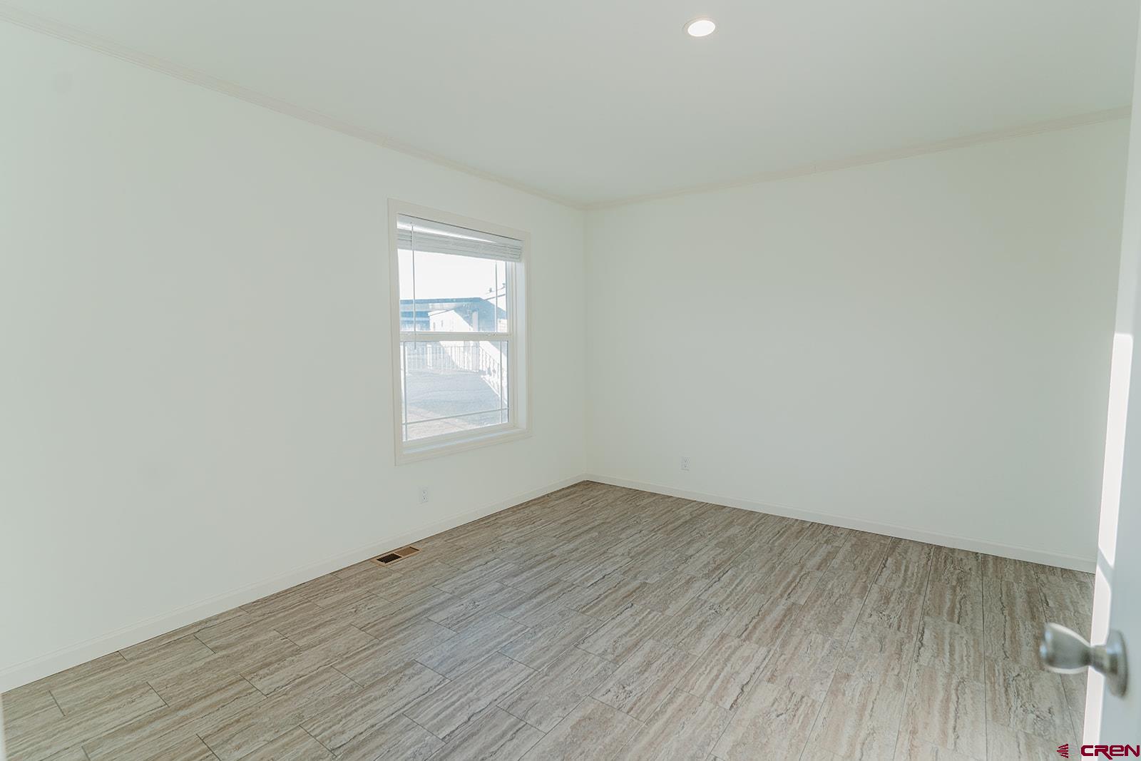 62650 Lasalle Road, Unit 343 Montrose, CO 81403 - Photo 13 of 24 an empty room with wooden floor and windows