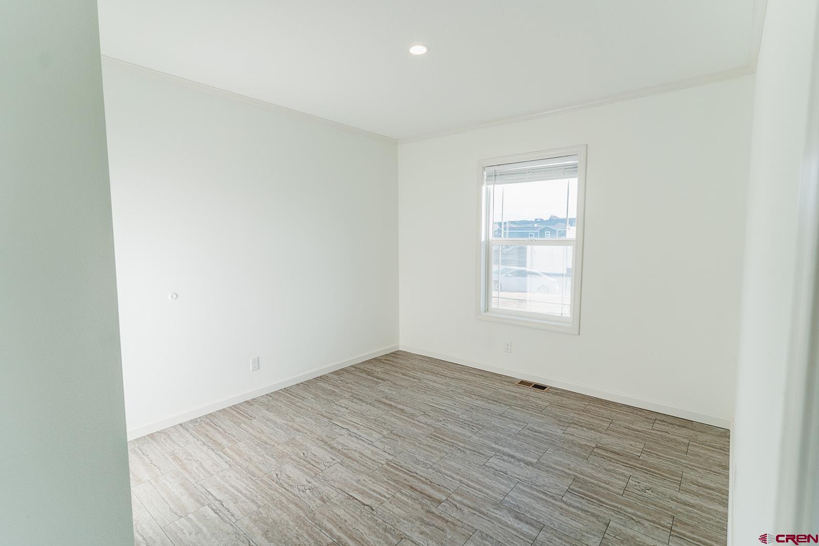 62650 Lasalle Road, Unit 343 Montrose, CO 81403 - Photo 10 of 24 an empty room with wooden floor and windows