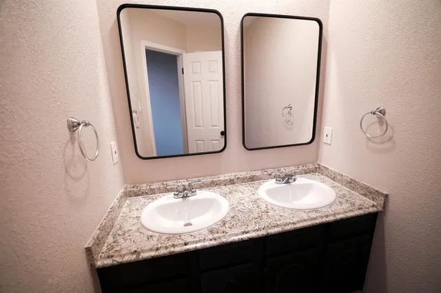 a bathroom with a granite countertop sink and a mirror