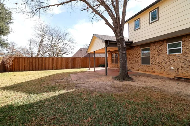 a view of a house with backyard and tree