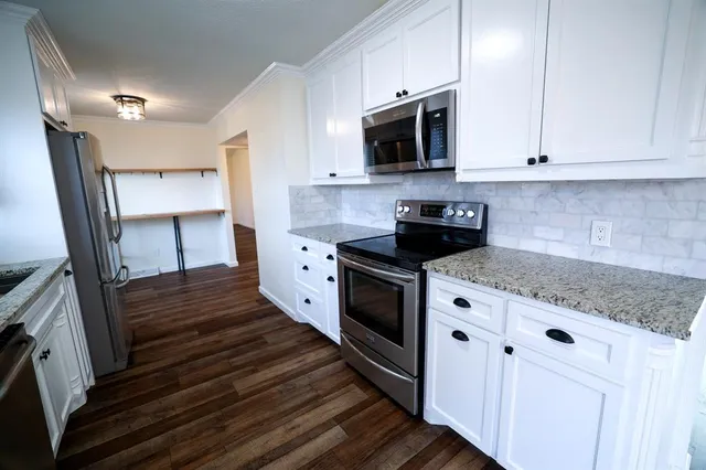 a kitchen with stainless steel appliances granite countertop a stove a microwave and a sink