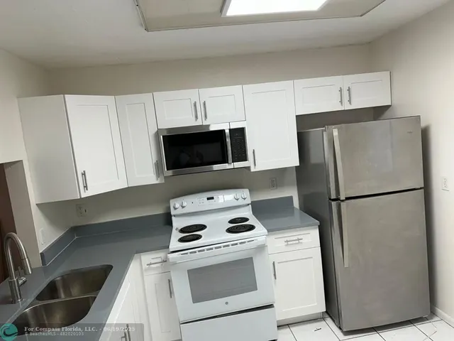 a kitchen with a refrigerator sink and microwave