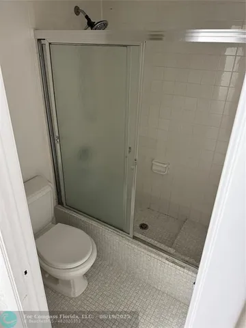 a white toilet sitting next to a shower