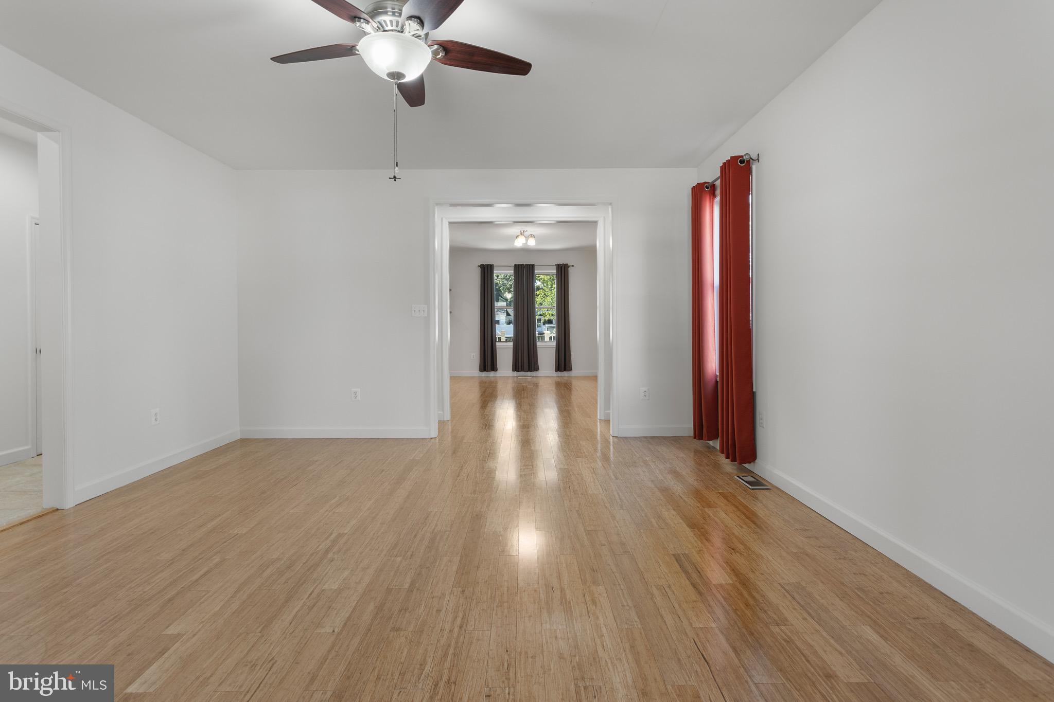4005 7th Street North Beach, MD 20714 - Photo 16 of 47 a view of a livingroom with wooden floor and a ceiling fan