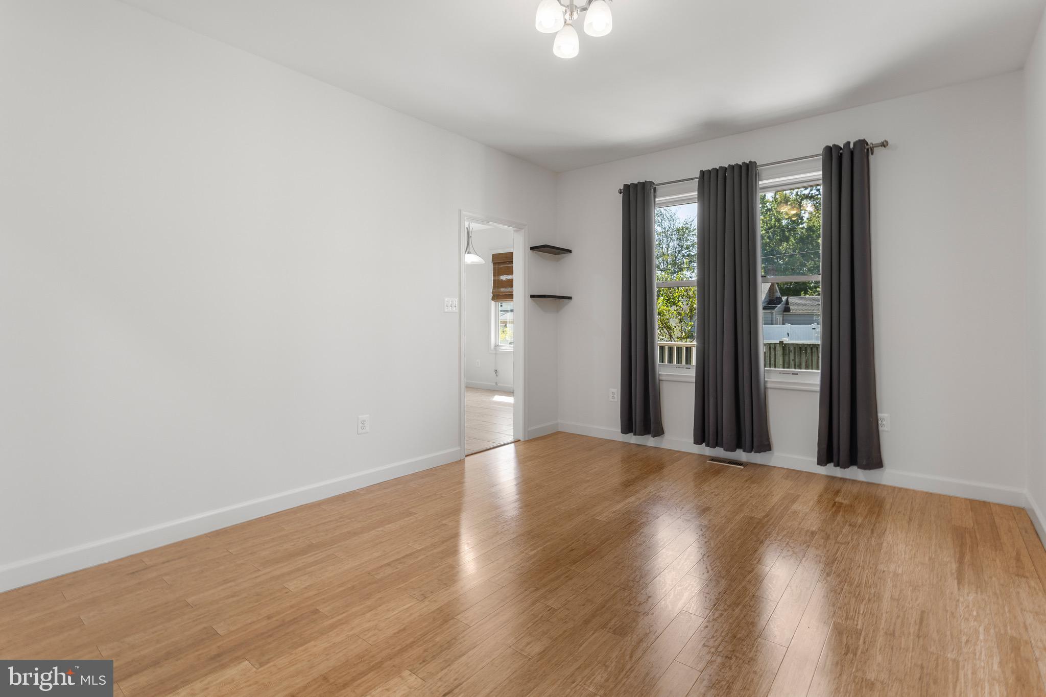 4005 7th Street North Beach, MD 20714 - Photo 20 of 47 a view of an empty room with wooden floor and a window