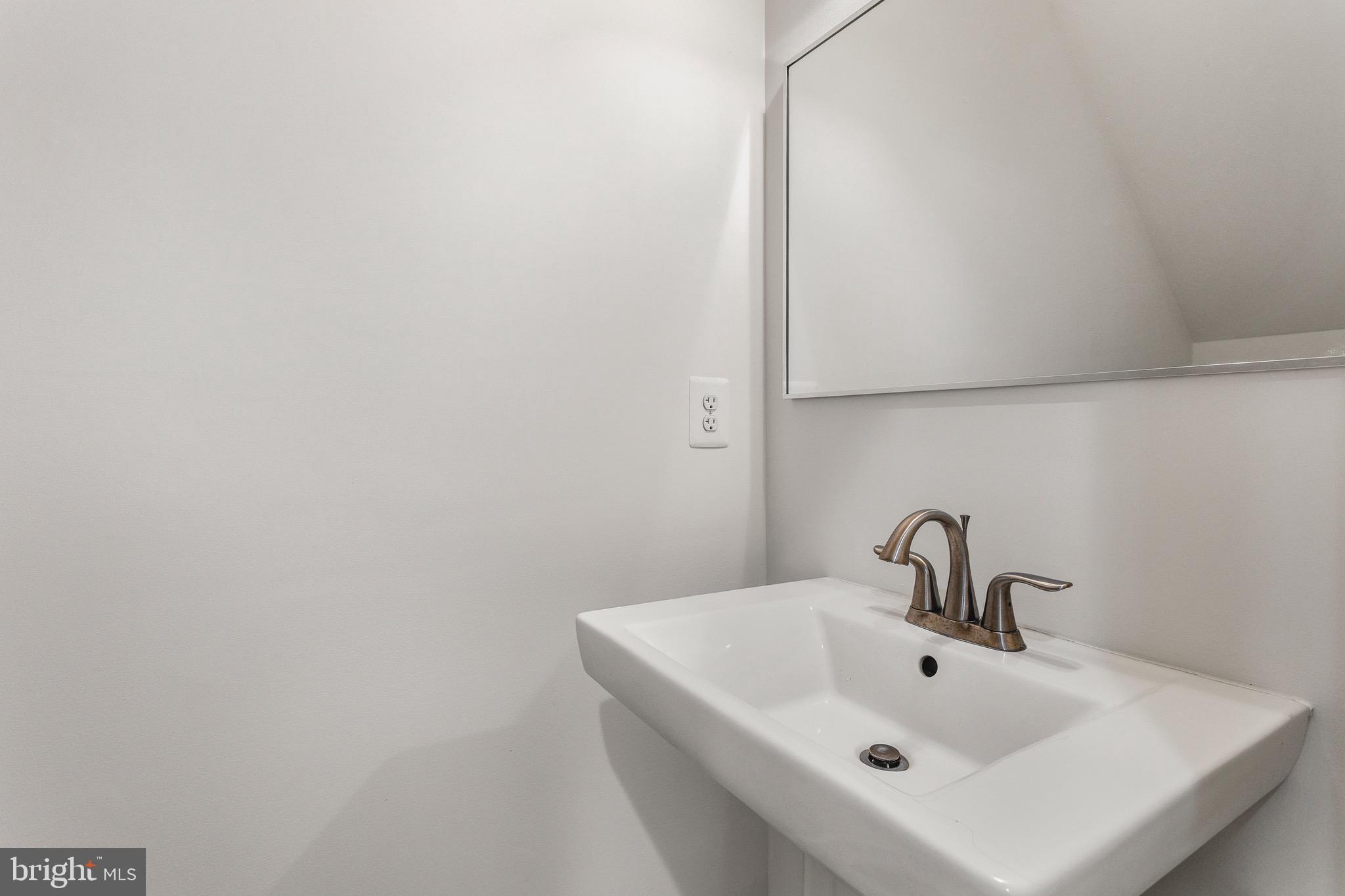 4005 7th Street North Beach, MD 20714 - Photo 21 of 47 a bathroom with a sink and mirror