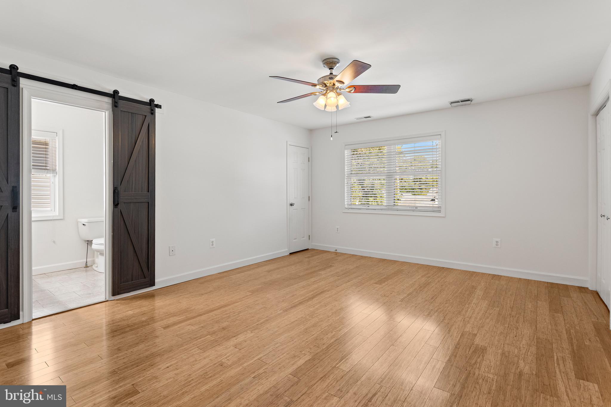 4005 7th Street North Beach, MD 20714 - Photo 22 of 47 a view of an empty room with wooden floor and a window