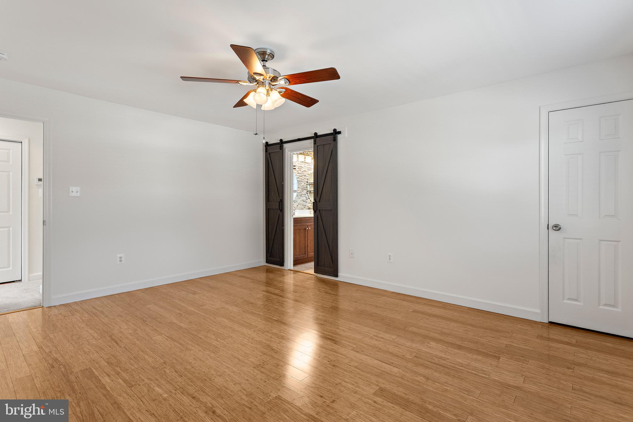 4005 7th Street North Beach, MD 20714 - Photo 25 of 47 a view of an empty room with wooden floor and a ceiling fan