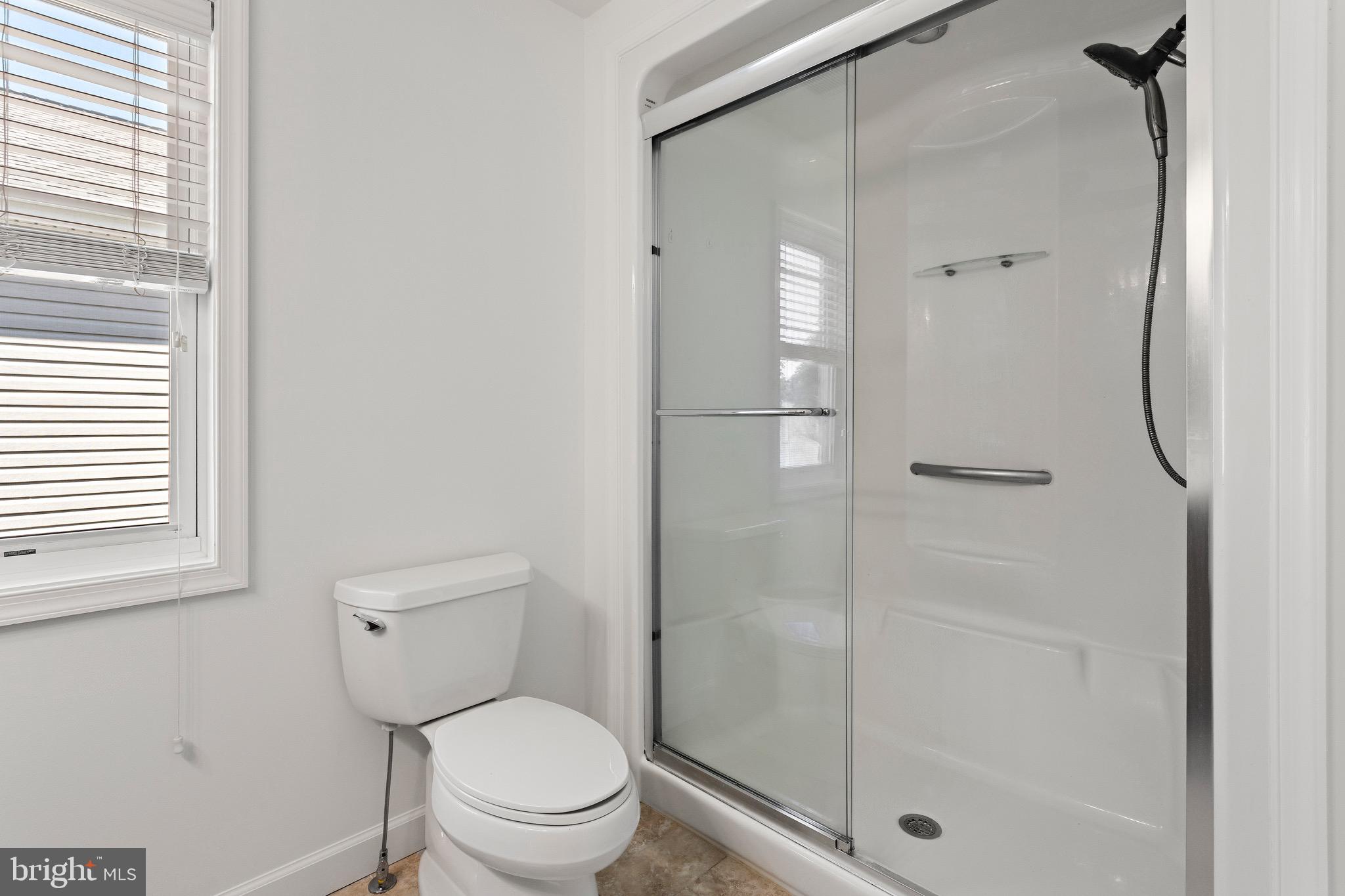 4005 7th Street North Beach, MD 20714 - Photo 27 of 47 a bathroom with a granite countertop toilet a sink and shower