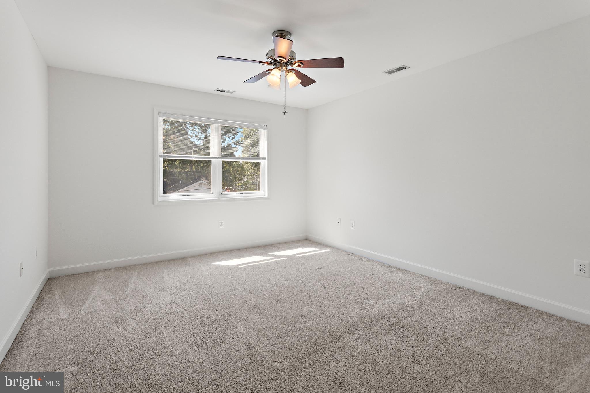 4005 7th Street North Beach, MD 20714 - Photo 34 of 47 an empty room with a window and a fan