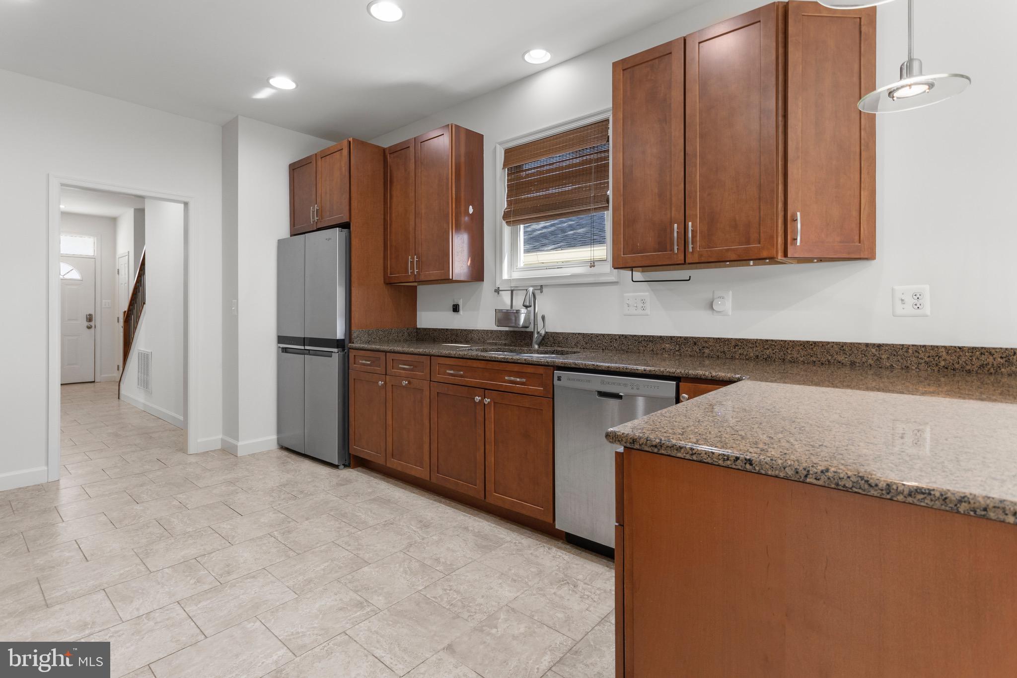 4005 7th Street North Beach, MD 20714 - Photo 9 of 47 a kitchen with stainless steel appliances granite countertop a sink refrigerator and cabinets