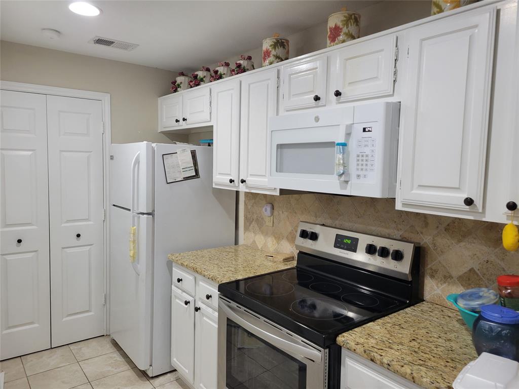 5565 Preston Oaks Road, Unit 117 Dallas, TX 75254 - Photo 9 of 24 a kitchen with cabinets and steel stainless steel appliances