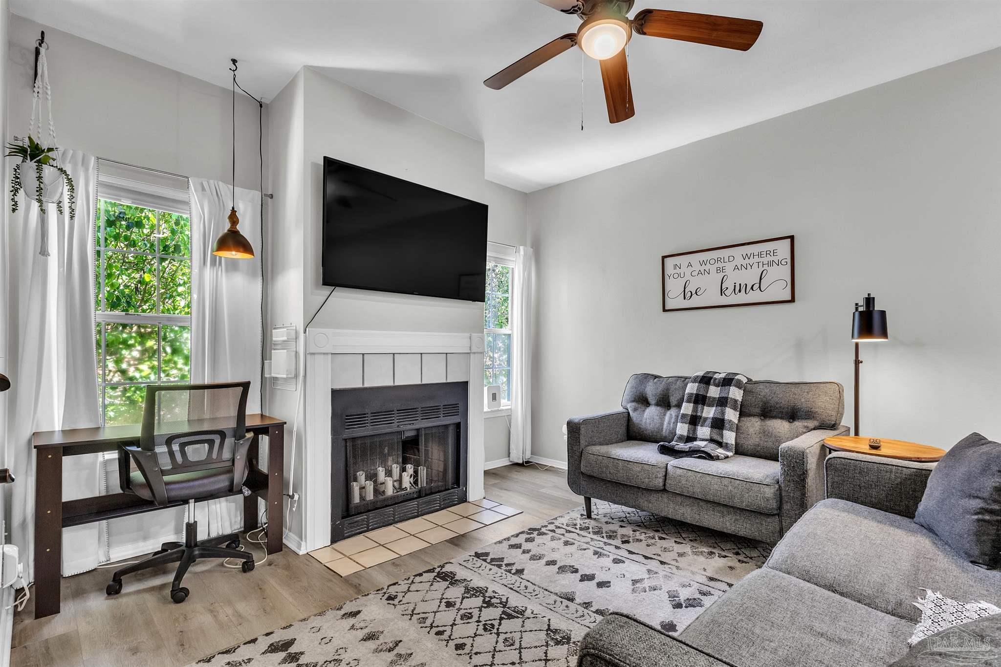 501 East Burgess Road, Unit F5 Pensacola, FL 32504 - Photo 4 of 12 a living room with furniture a flat screen tv and a fireplace