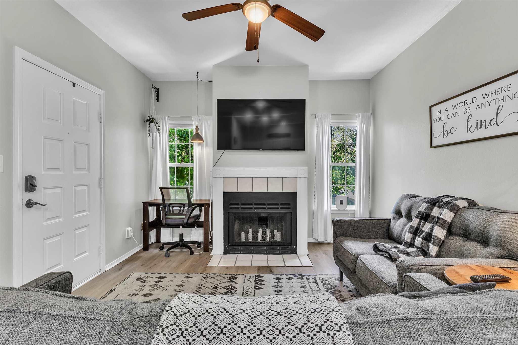 501 East Burgess Road, Unit F5 Pensacola, FL 32504 - Photo 5 of 12 a living room with furniture a flat screen tv and a fireplace