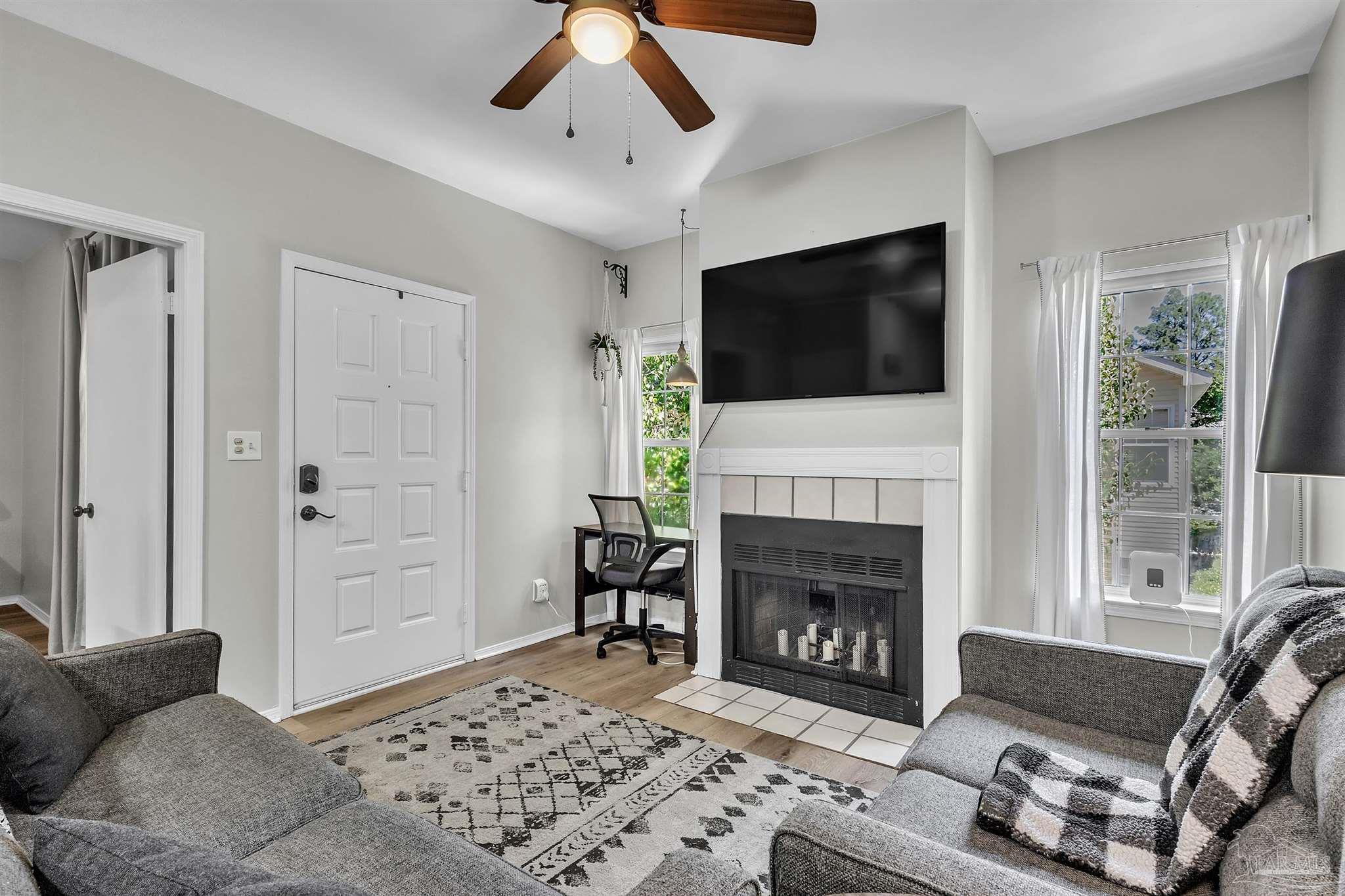501 East Burgess Road, Unit F5 Pensacola, FL 32504 - Photo 6 of 12 a living room with furniture a flat screen tv and a fireplace