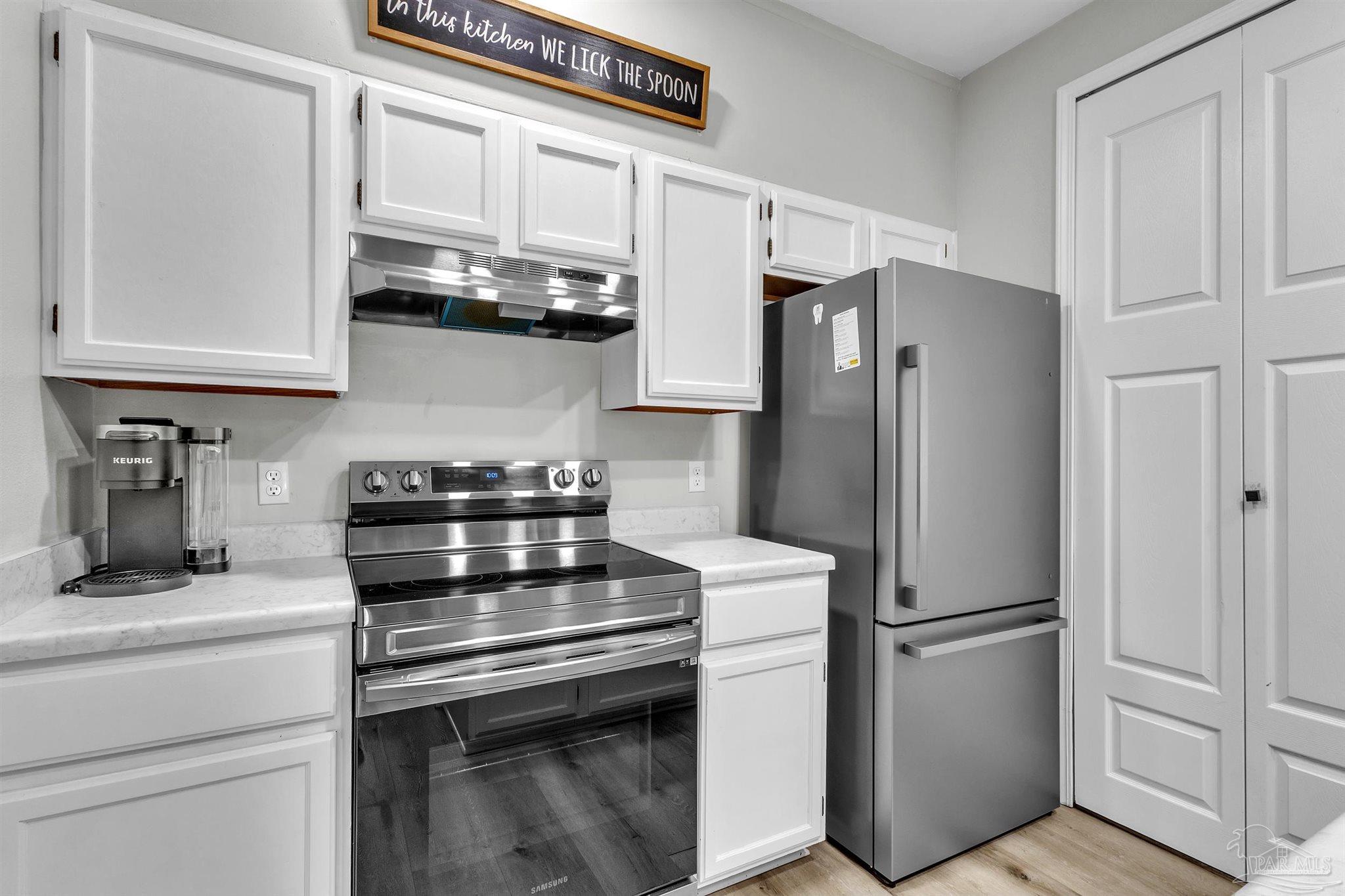 501 East Burgess Road, Unit F5 Pensacola, FL 32504 - Photo 7 of 12 a kitchen with stainless steel appliances a refrigerator stove and cabinets