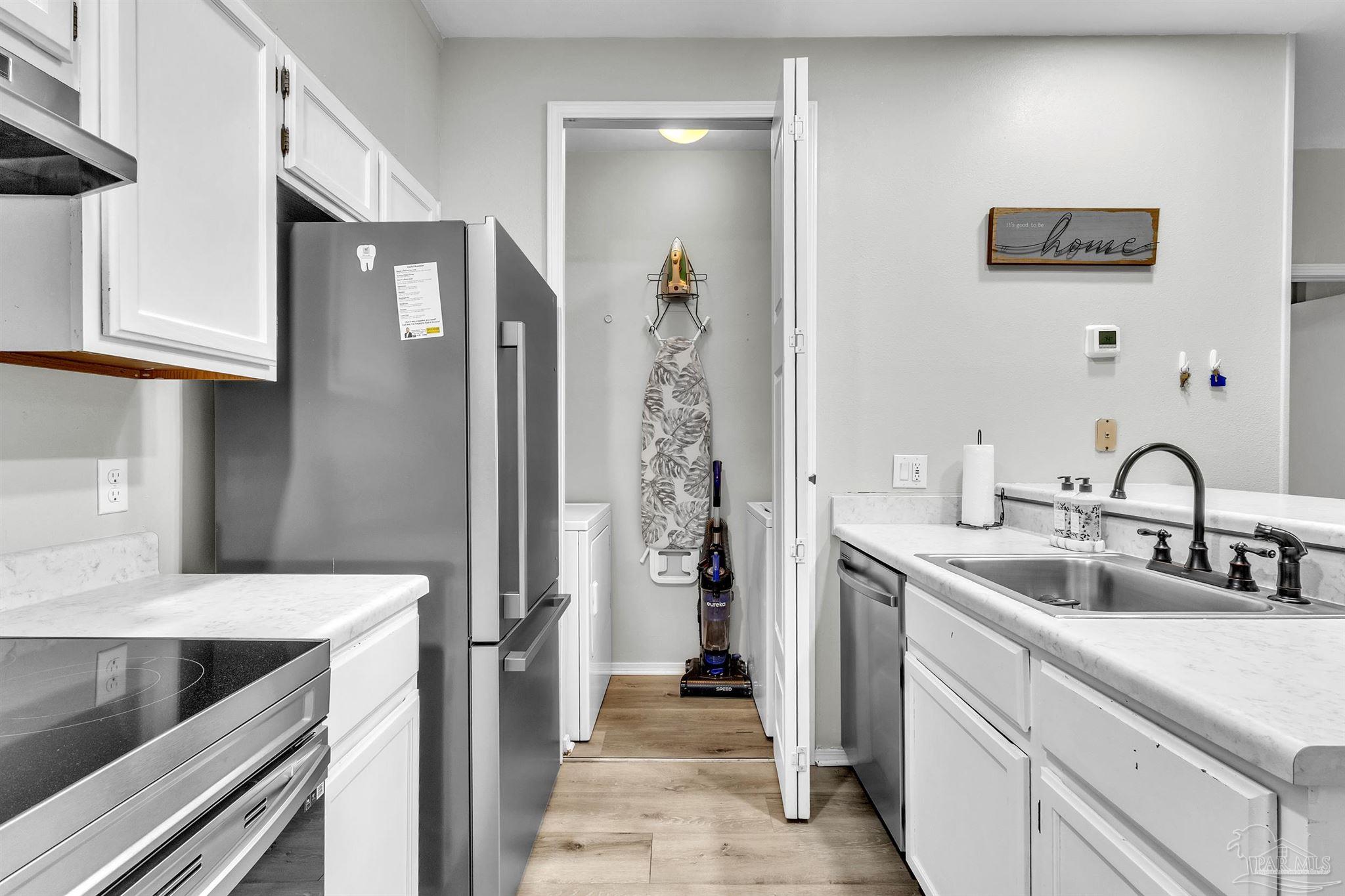 501 East Burgess Road, Unit F5 Pensacola, FL 32504 - Photo 8 of 12 a kitchen with a sink and a refrigerator