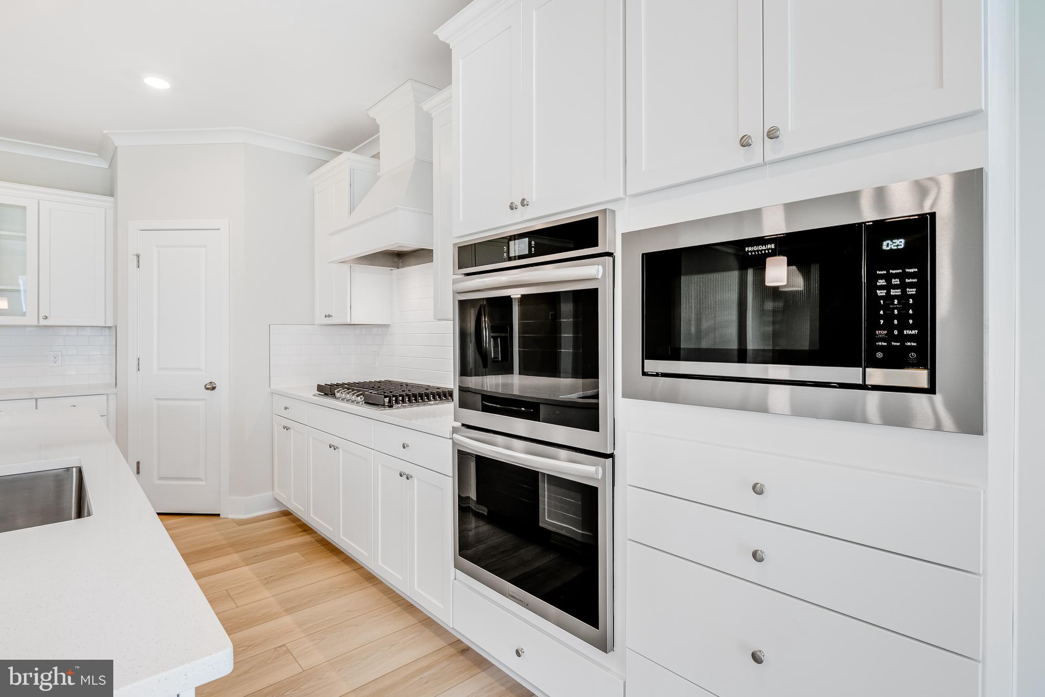 201 Mariners Circle Milton, DE 19968 - Photo 10 of 39 a kitchen with stainless steel appliances white cabinets and stove