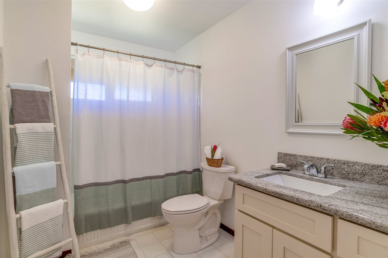 238 South Holokai Road Haiku, HI 96708 - Photo 14 of 28 a bathroom with a granite countertop sink toilet and shower