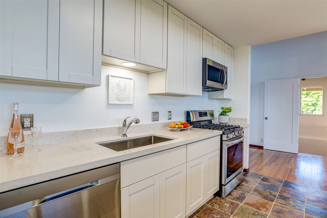 238 South Holokai Road Haiku, HI 96708 - Photo 10 of 28 a kitchen with stainless steel appliances granite countertop a sink a stove and a wooden floors
