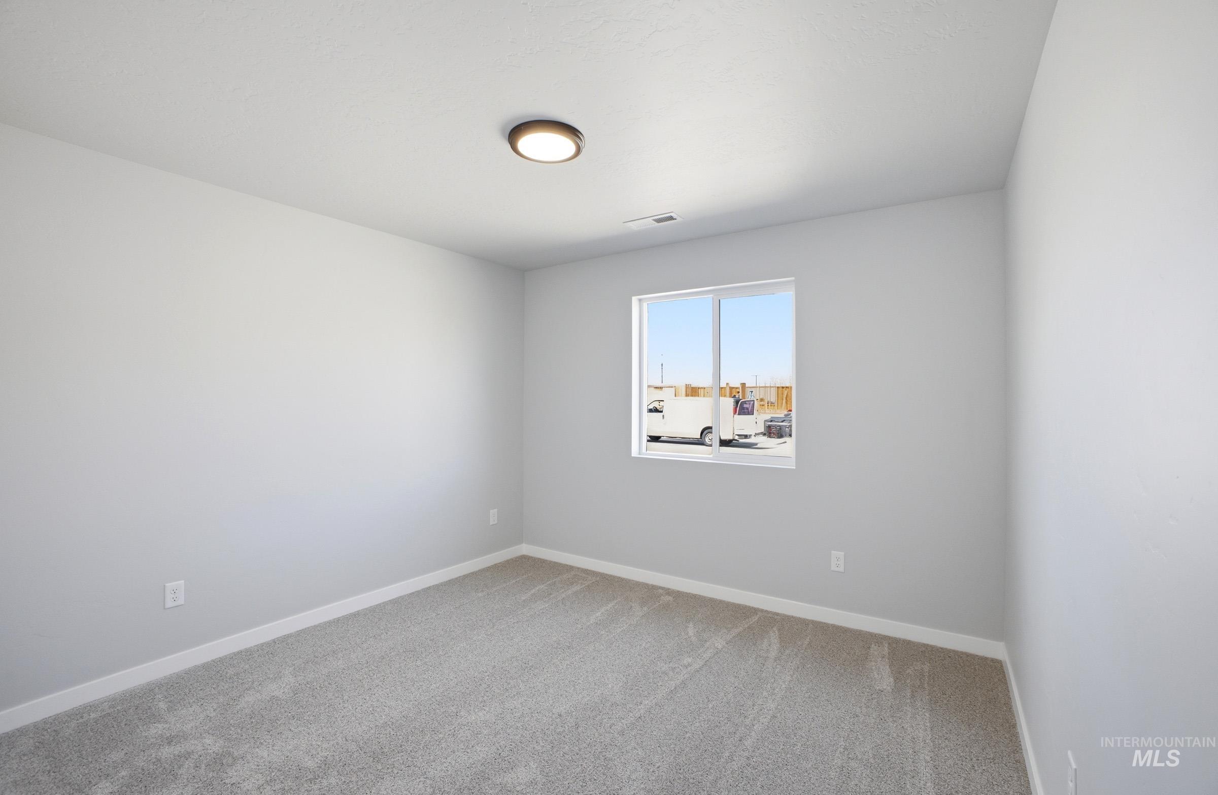 14106 Winding Street Caldwell, ID 83607 - Photo 11 of 18 Neutral tone carpeting with white baseboards and walls