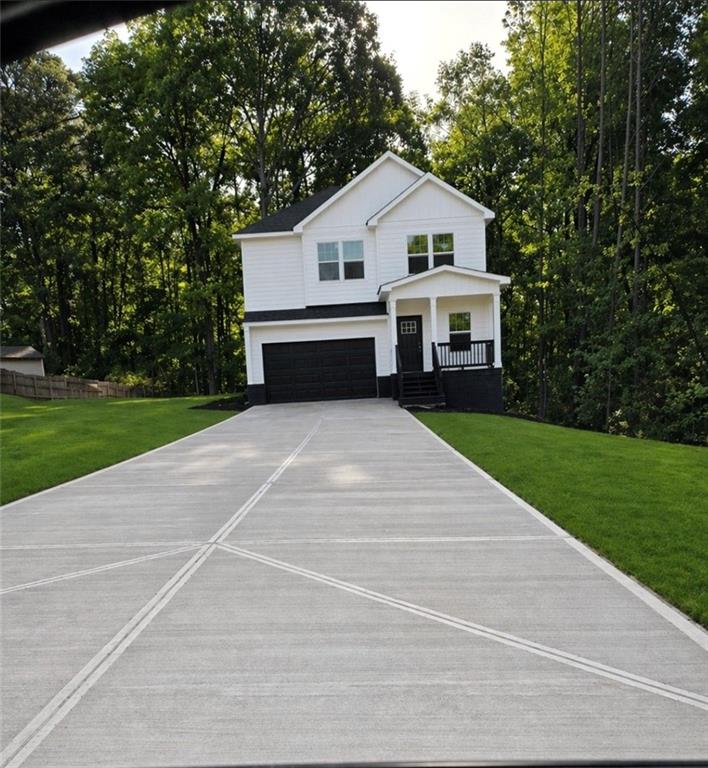 131 Forest Place Stockbridge, GA 30281 - Photo 1 of 2 a view of a white house with a big yard and large trees