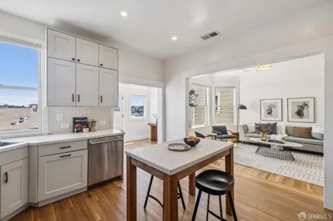 a view of a kitchen area with furniture and wooden floor