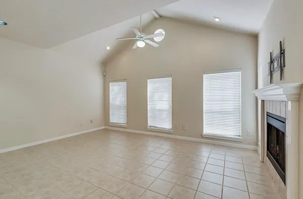 a view of an empty room with a fireplace and a window