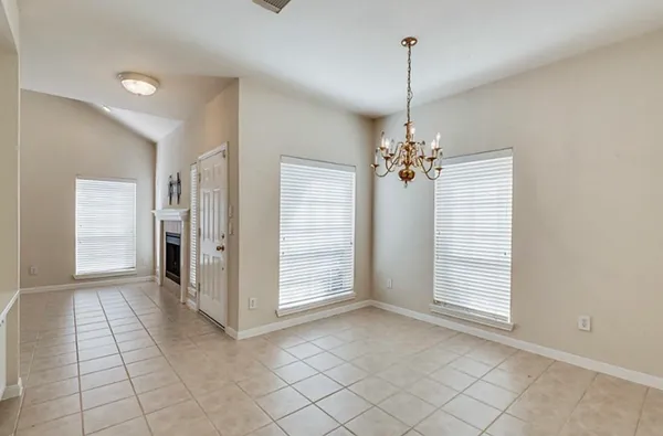 a view of a livingroom with a chandelier fan and windows