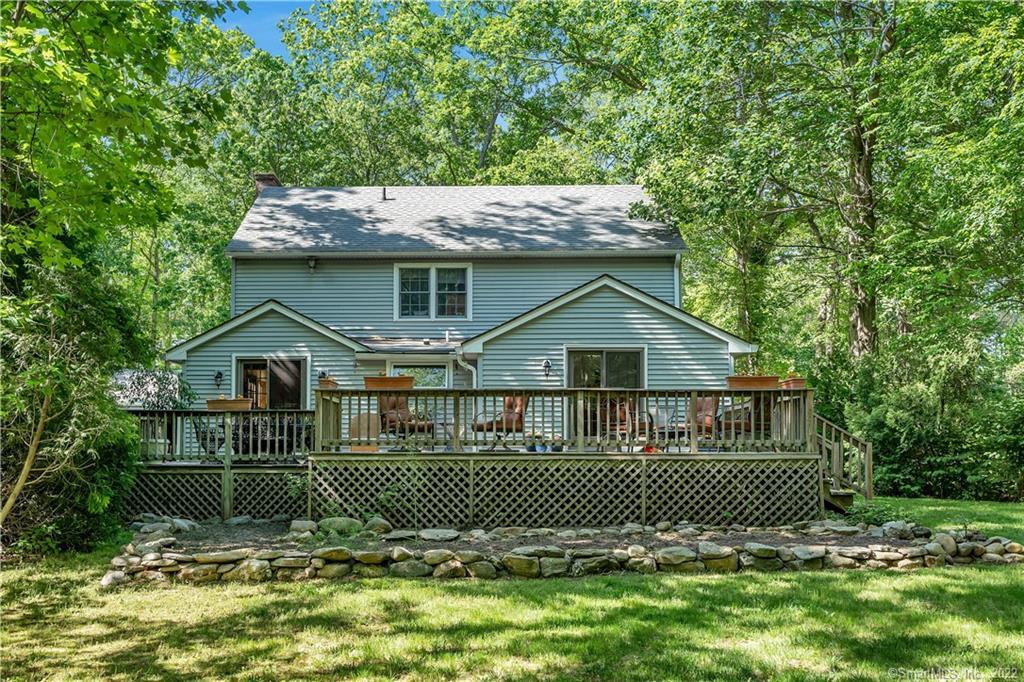 157 Dennison Road Westbrook, CT 06498 - Photo 1 of 1 A view of the back of the home which has a wrap around 2 tier deck. The raised stone lined area is for your vegetable or flower garden. The yard is level and there's lots of room for outdoor recreation