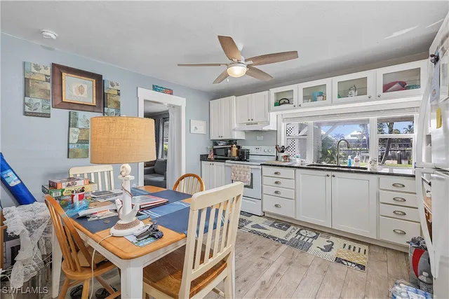 a kitchen with stainless steel appliances kitchen island granite countertop a table chairs and a refrigerator