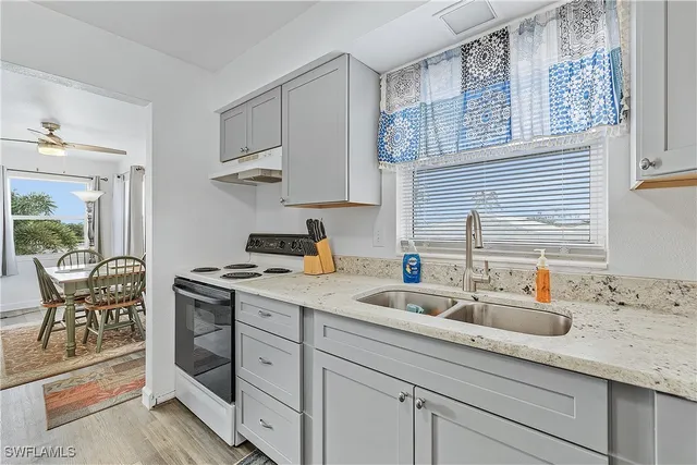 a kitchen with stainless steel appliances granite countertop a sink stove and cabinets