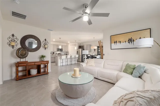 a kitchen with kitchen island granite countertop a stove a sink a dining table and chairs with wooden floor