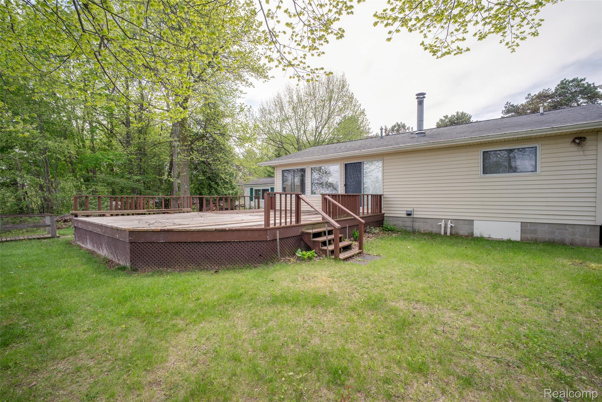 6240 Lakeshore Road Palms, MI 48465 - Photo 26 of 38 Back of property with a wooden deck and crawl space