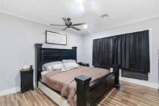 a bedroom with a bed a dresser and a window