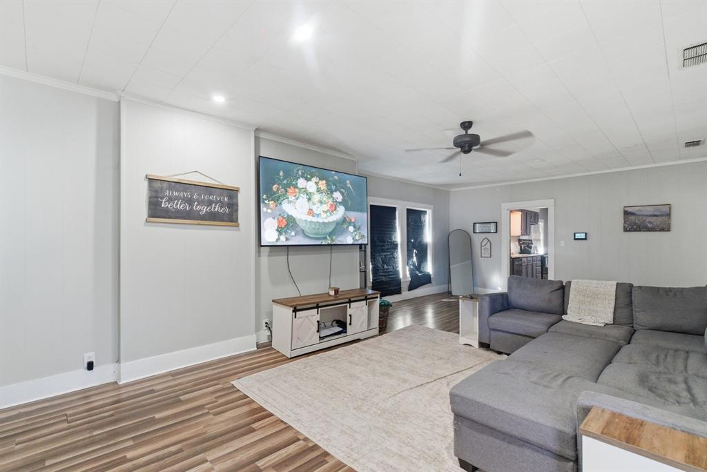 1317 4th Street Graham, TX 76450 - Photo 3 of 25 Living room with wood finished floors, a ceiling fan, and crown molding