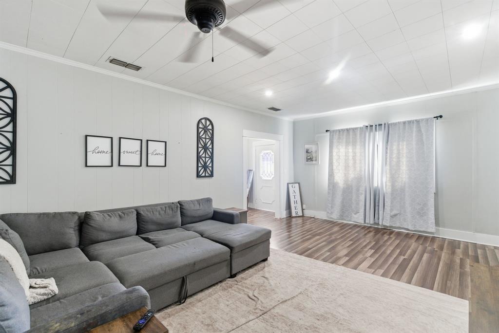 1317 4th Street Graham, TX 76450 - Photo 5 of 25 Living room featuring wood finished floors, a ceiling fan, and crown molding