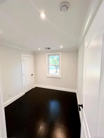 a bedroom with a bed wooden floor and window