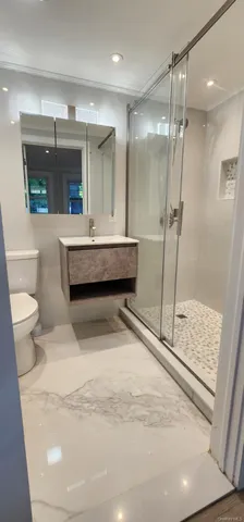 a bathroom with a double vanity sink toilet and shower
