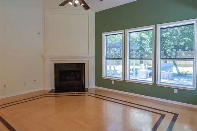 a view of an empty room with window and fire place