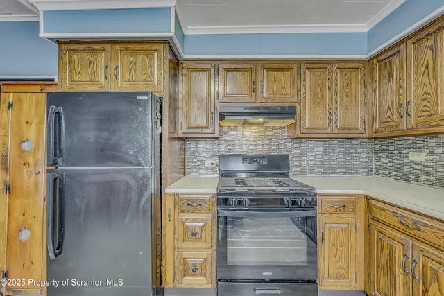 a kitchen with stainless steel appliances granite countertop a refrigerator and a stove top oven