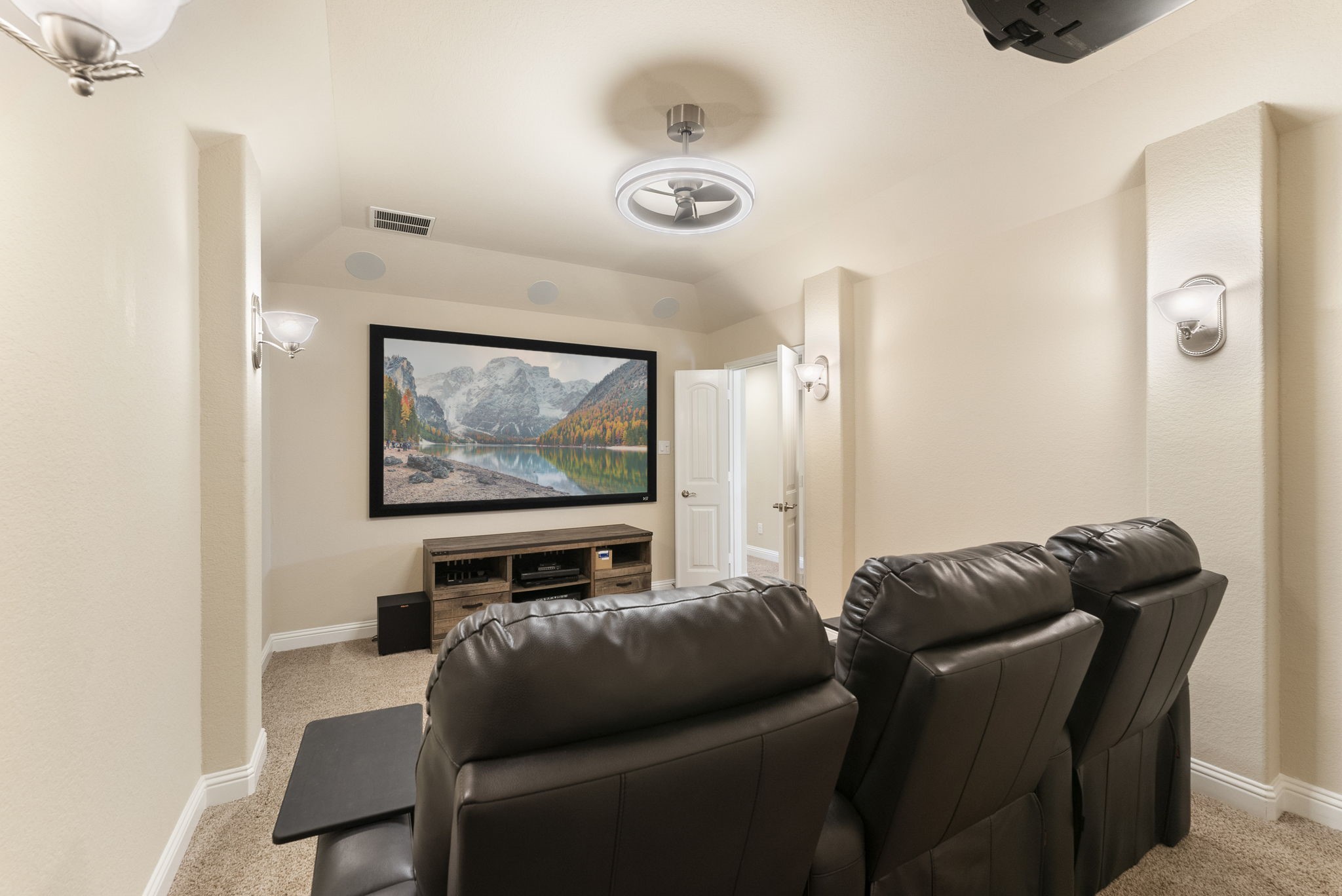 3565 Falcon Way Conroe, TX 77304 - Photo 28 of 50 Dedicated media room featuring theater seating, a large projection screen, built-in speakers, and a comfortable entertainment setup.