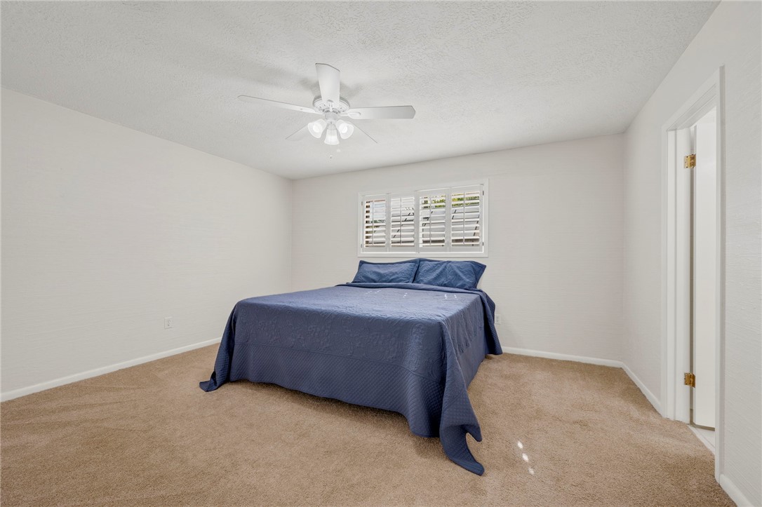 2810 Hillside Drive Bryan, TX 77802 - Photo 11 of 22 a spacious bedroom with a bed and a chandelier