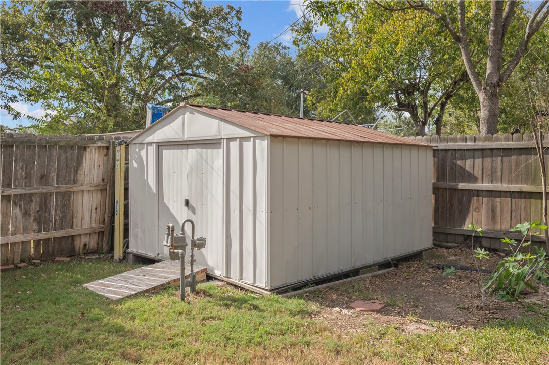 2810 Hillside Drive Bryan, TX 77802 - Photo 19 of 22 a backyard of a house with a small barn plants and large tree