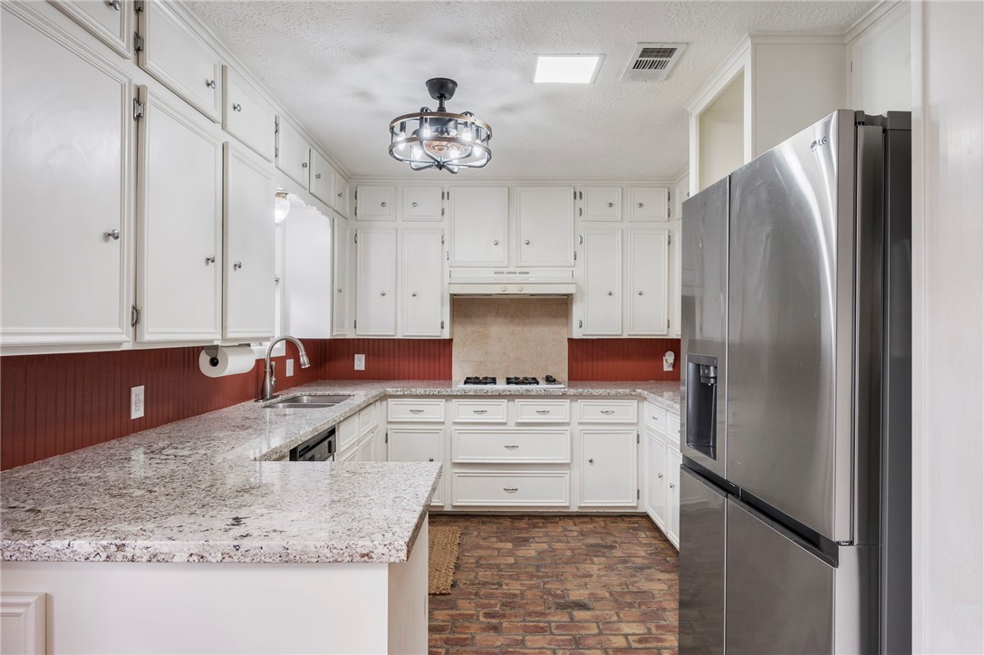 2810 Hillside Drive Bryan, TX 77802 - Photo 7 of 22 a kitchen with stainless steel appliances granite countertop a sink stove and refrigerator