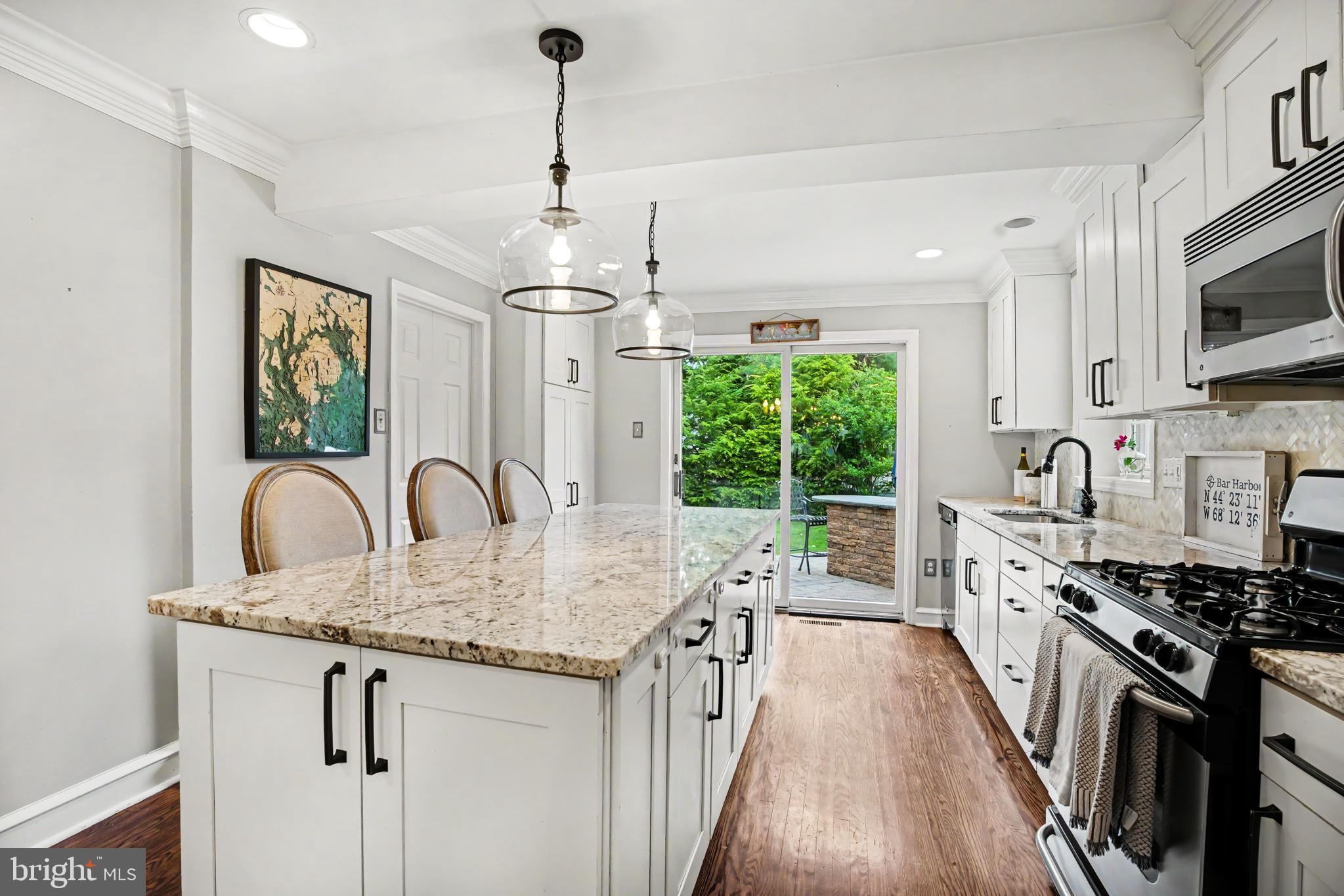235 Hopkins Road Haddonfield, NJ 08033 - Photo 9 of 47 a kitchen with stainless steel appliances granite countertop a stove top oven a sink dishwasher a dining table and chairs with wooden floor