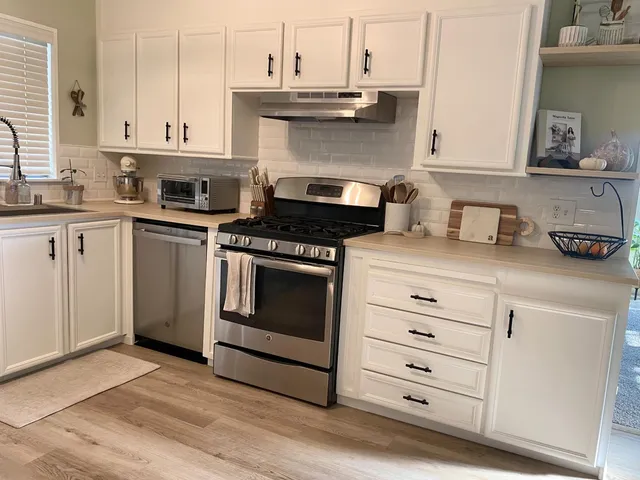 a kitchen with stainless steel appliances a refrigerator and a stove top oven