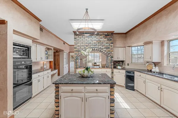 a kitchen with stainless steel appliances granite countertop a stove and more cabinets