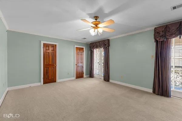 a view of an empty room with window and chandelier fan