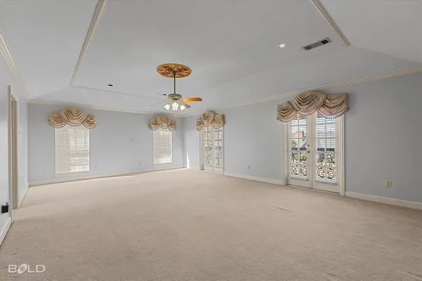 en empty room with windows and chandelier